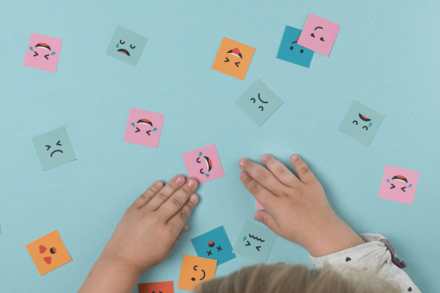 mains-bebe-jouant-avec-des-visages-souriants